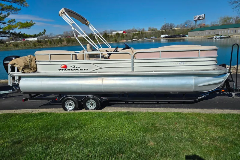 Slide: The Image of 2016 Sun Tracker Party Barge 24 DLX pontoon boat on trailer by a lake. - 9
