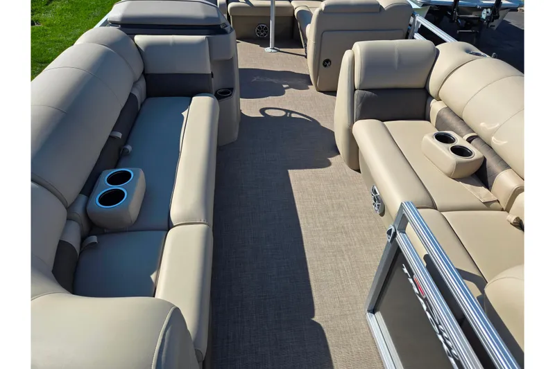 Slide: The Image of 2024 Sun Tracker Party Barge 20 DLX interior with beige seating and cup holders. - 10