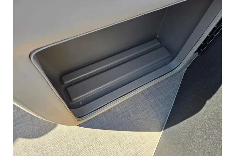 Slide: The Image of 2024 Sun Tracker Party Barge 20 DLX storage compartment with gray interior. - 13