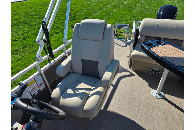 Slide: The Image of 2024 Sun Tracker Party Barge 20 DLX interior with plush seating and steering wheel. - 14