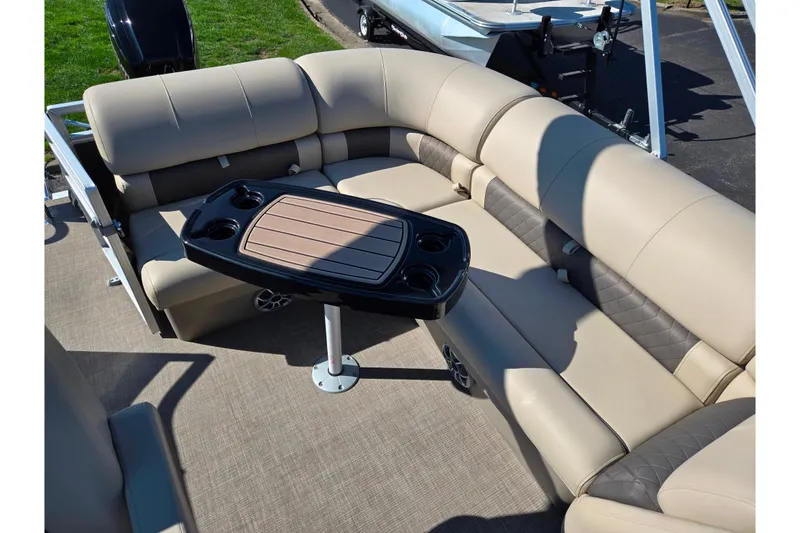 Slide: The Image of 2024 Sun Tracker Party Barge 20 DLX interior with beige seating and central table. - 16