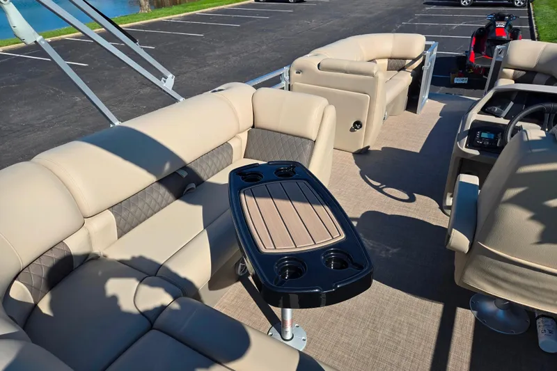 Slide: The Image of 2024 Sun Tracker Party Barge 20 DLX interior with beige seating and table. - 18