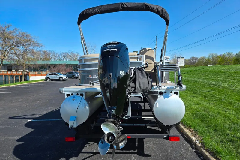 Slide: The Image of 2024 Sun Tracker Party Barge 20 DLX pontoon boat with outboard motor in parking lot. - 2