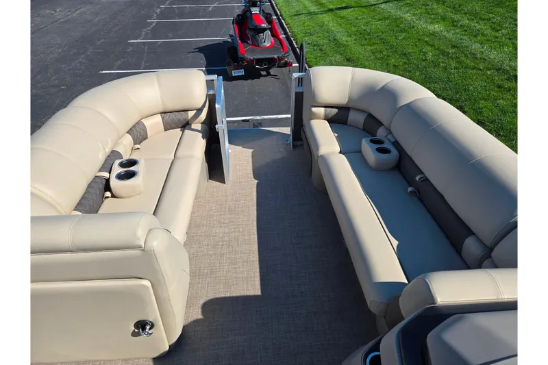 Slide: The Image of 2024 Sun Tracker Party Barge 20 DLX interior with beige seating and cup holders. - 21