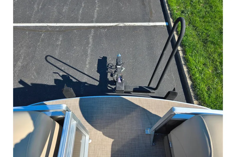 Slide: The Image of 2024 Sun Tracker Party Barge 20 DLX pontoon boat on trailer, parked on asphalt. - 22