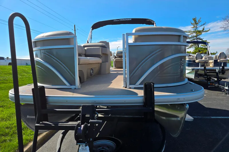 Slide: The Image of 2024 Sun Tracker Party Barge 20 DLX pontoon boat on trailer, sunny day. - 6