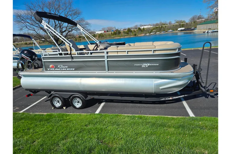 Slide: The Image of 2024 Sun Tracker Party Barge 20 DLX pontoon boat parked near a scenic lake. - 9