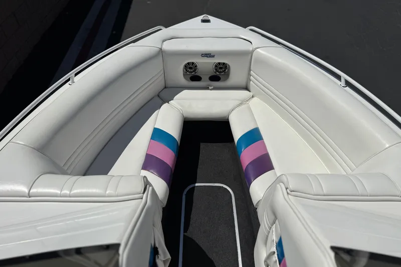 Slide: The Image of Interior of a 1996 Warlock Ultimate boat with white and colorful seating. - 11