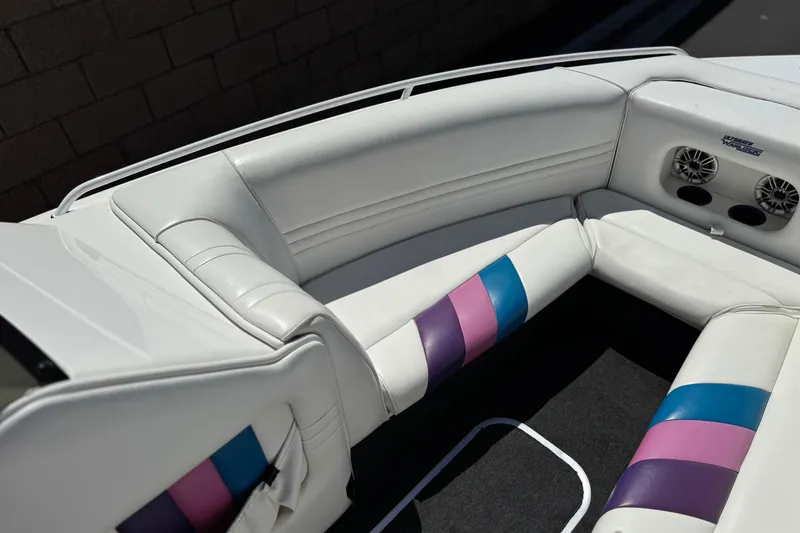 Slide: The Image of Interior of a 1996 Warlock Ultimate boat with white and colorful seating. - 12