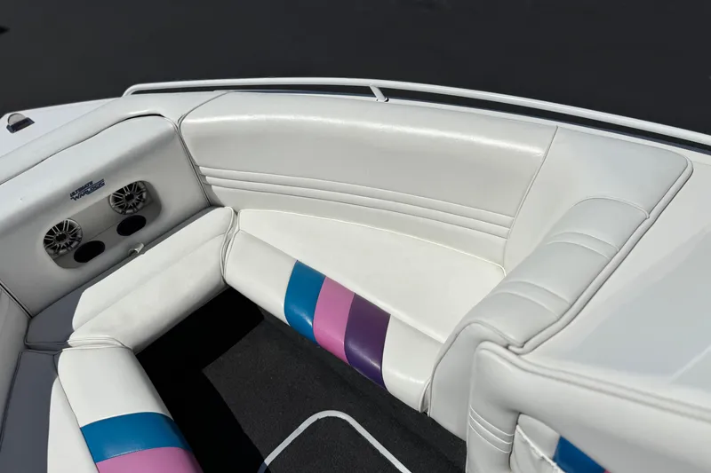 Slide: The Image of Interior of a 1996 Warlock Ultimate boat with white seating and colorful accents. - 13