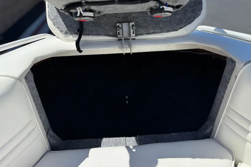 Slide: The Image of Open storage compartment in a 1996 Warlock Ultimate boat, featuring white upholstery. - 14