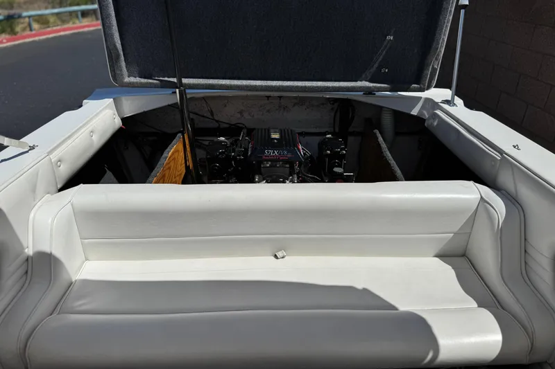 Slide: The Image of 1996 Warlock Ultimate boat engine compartment with open hatch and white seating. - 17