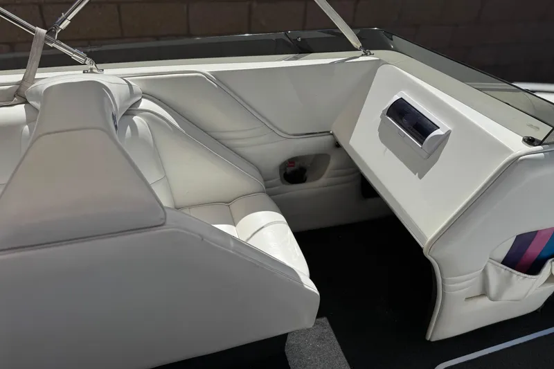 Slide: The Image of Interior of a 1996 Warlock Ultimate boat with white seating and dashboard. - 23