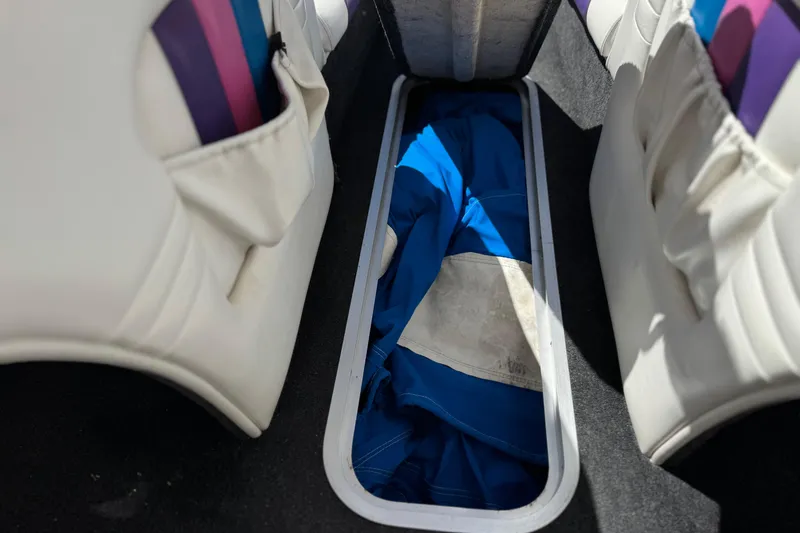 Slide: The Image of Interior storage compartment of a 1996 Warlock Ultimate boat with blue fabric inside. - 26