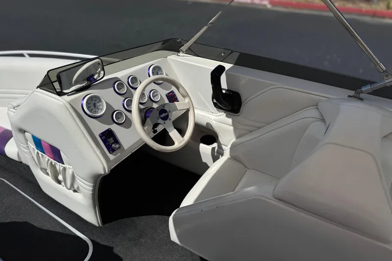 Slide: The Image of Interior of a 1996 Warlock Ultimate boat with white seating and dashboard controls. - 28