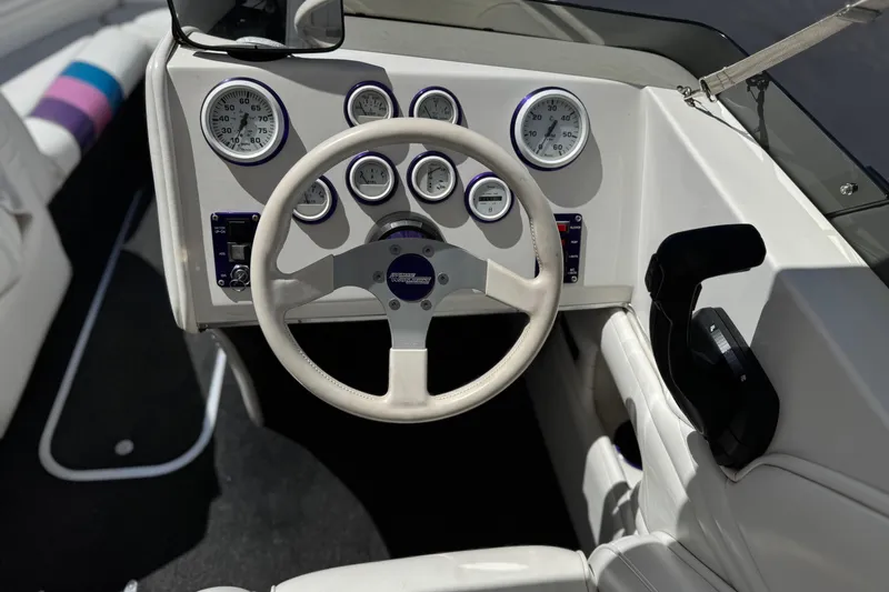 Slide: The Image of Steering wheel and dashboard of a 1996 Warlock Ultimate boat, featuring multiple gauges. - 29