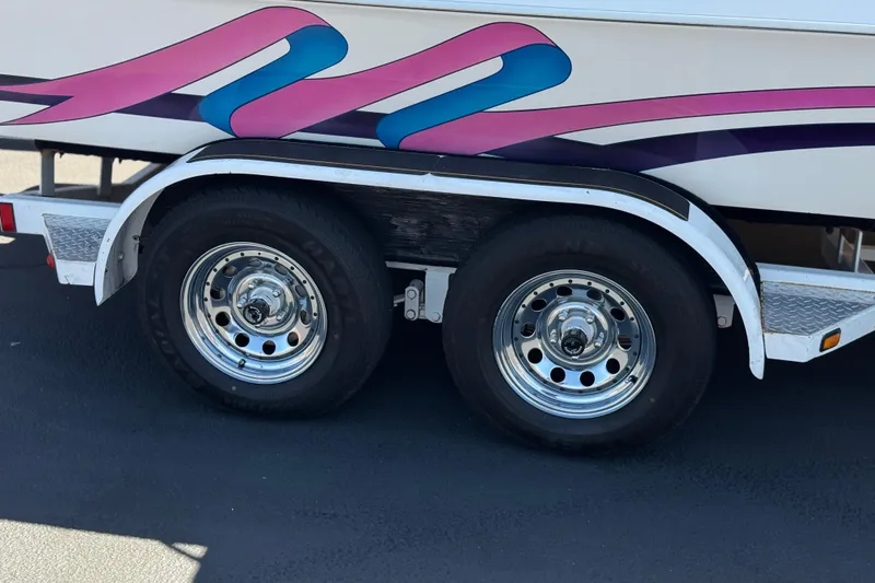 Slide: The Image of Trailer wheels of a 1996 Warlock Ultimate boat with colorful side graphics. - 31