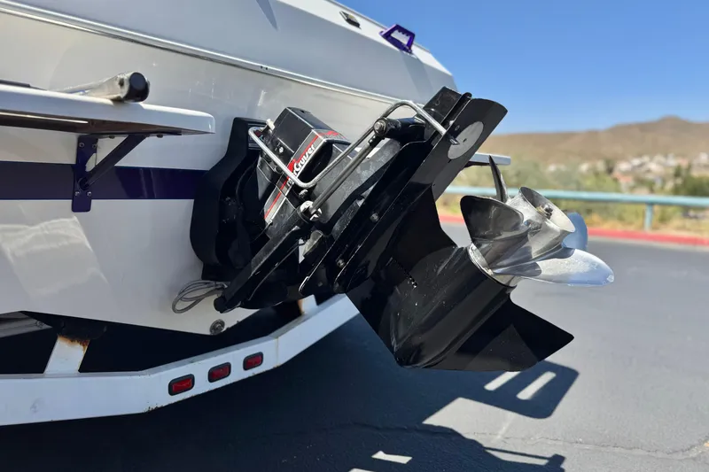 Slide: The Image of 1996 Warlock Ultimate boat stern with propeller and drive system, parked on asphalt. - 7