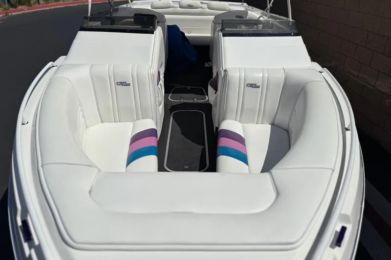Slide: The Image of 1996 Warlock Ultimate boat interior with white seating and colorful accents. - 9