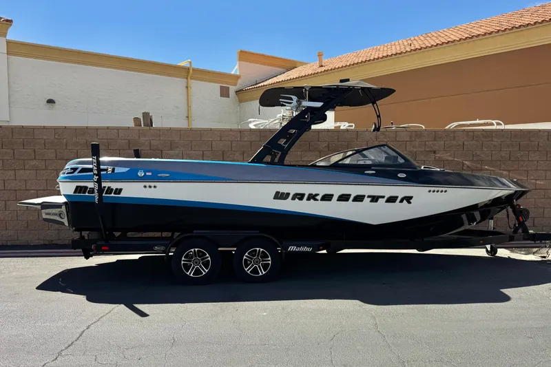 The Image of 2015 Malibu Wakesetter 247 LSV boat on trailer, parked outdoors. - 0