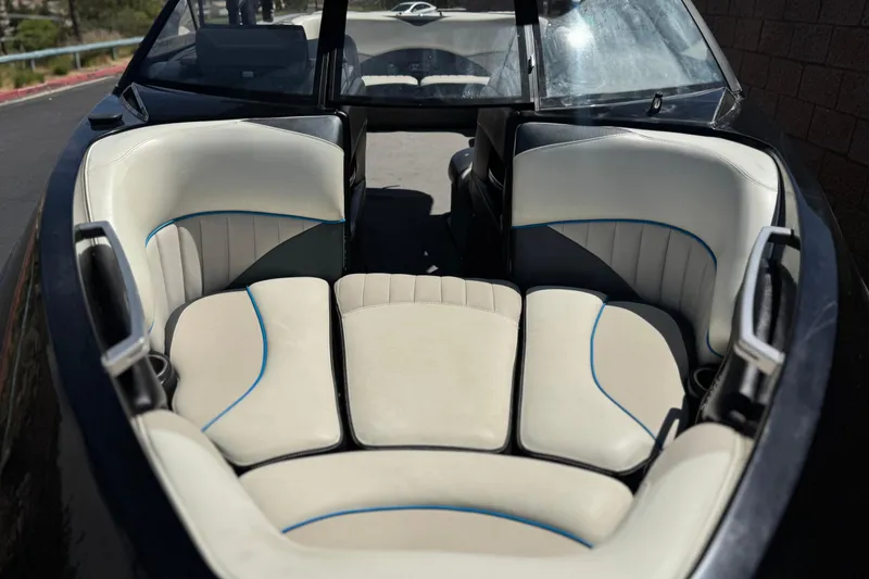 Slide: The Image of 2015 Malibu Wakesetter 247 LSV boat interior with white and blue-trimmed seating. - 12