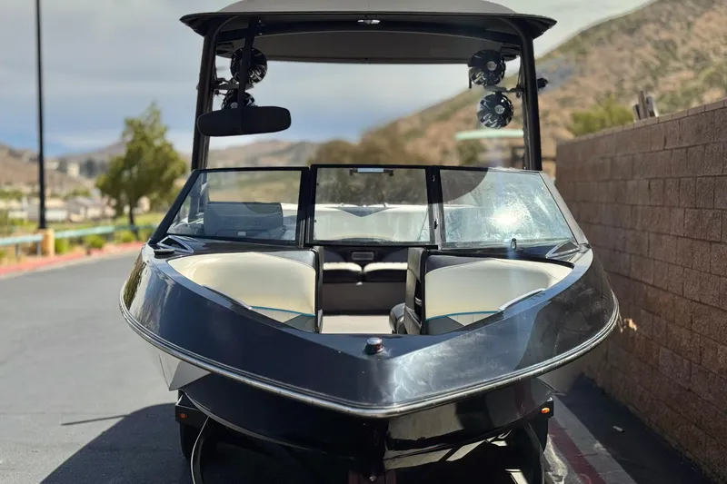 Slide: The Image of 2015 Malibu Wakesetter 247 LSV boat, front view, parked outdoors. - 2