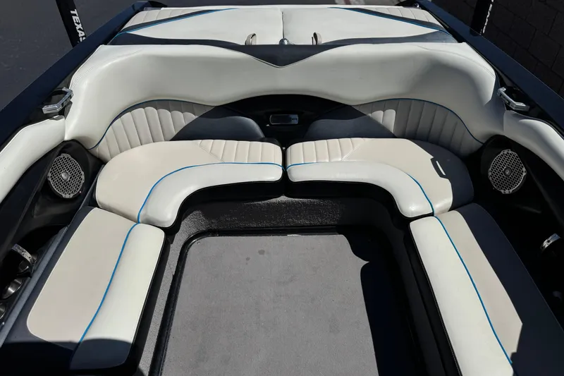 Slide: The Image of 2015 Malibu Wakesetter 247 LSV boat interior with white and blue-trimmed seating. - 21