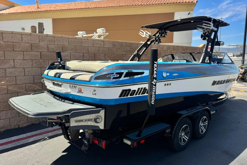 Slide: The Image of 2015 Malibu Wakesetter 247 LSV boat with trailer, parked outdoors. - 5