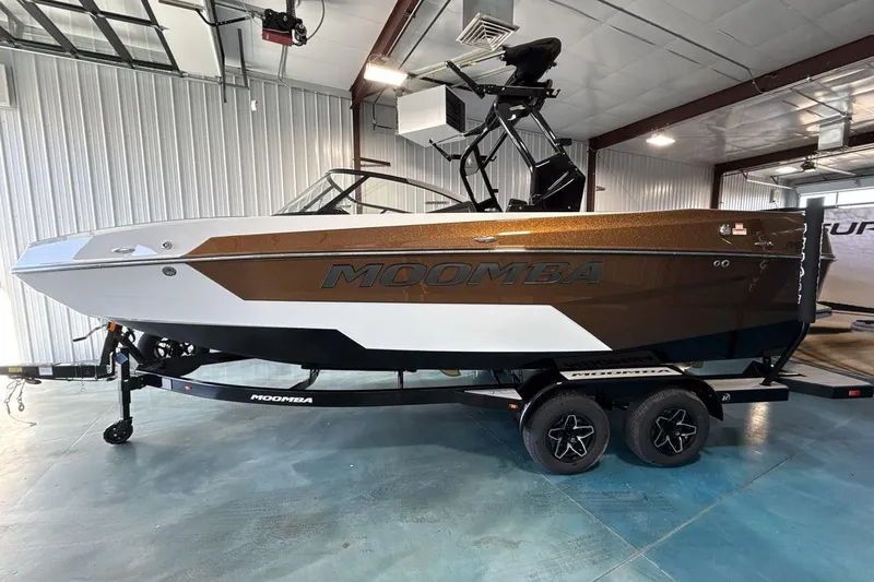 The Image of 2026 Moomba Max boat in showroom, brown and white design on trailer. - 1