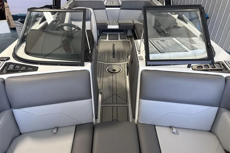 Slide: The Image of 2026 Moomba Max boat interior with gray seating and open windshield. - 12