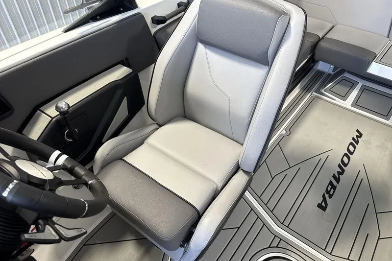 Slide: The Image of 2026 Moomba Max boat interior with sleek gray seating and modern steering wheel design. - 13