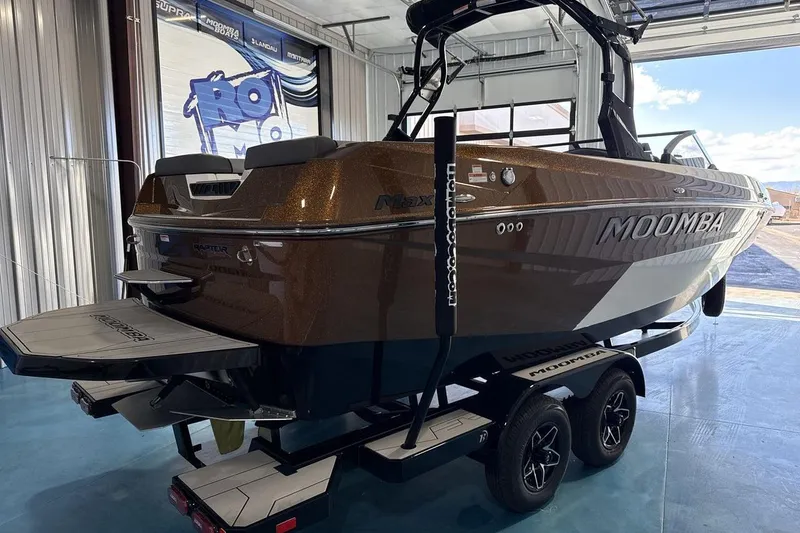 Slide: The Image of 2026 Moomba Max boat in showroom, brown exterior, on trailer. - 5