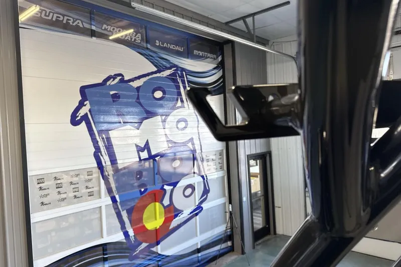 Slide: The Image of 2026 Moomba Tykon boat showroom with vibrant wall graphics and sleek design elements. - 22