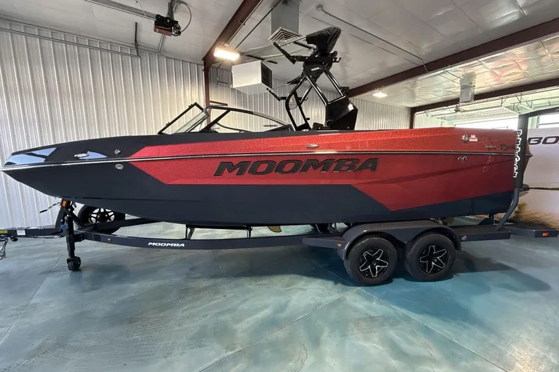 Slide: The Image of 2026 Moomba Tykon boat in showroom, featuring sleek red and black design on trailer. - 3