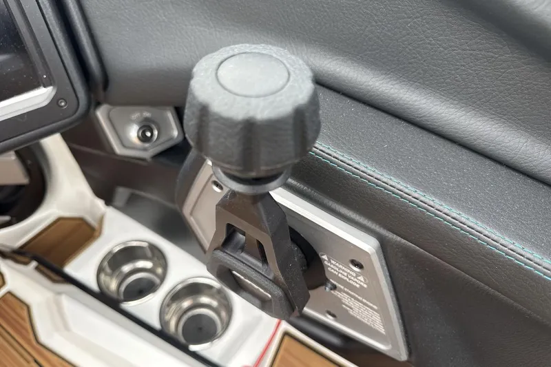 Slide: The Image of Interior detail of 2026 Supra SV, featuring control knob and cup holders. - 16
