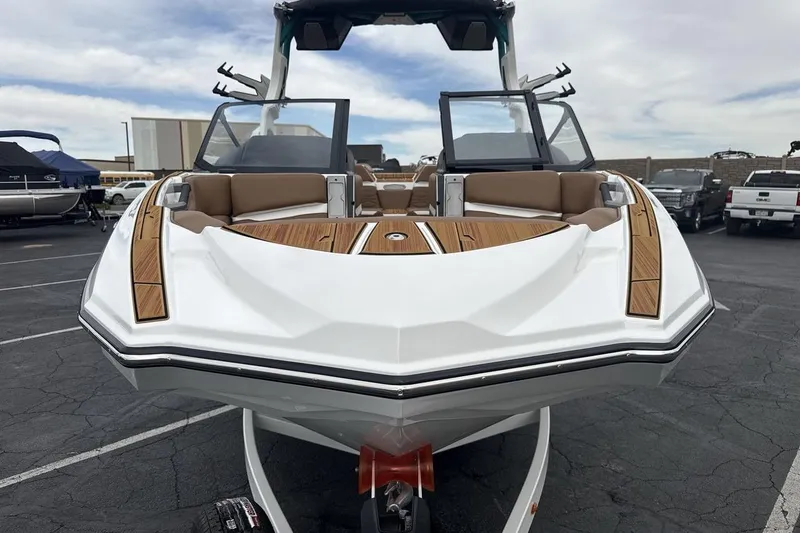 Slide: The Image of 2026 Supra SV boat with sleek design and wood accents in a parking lot. - 8