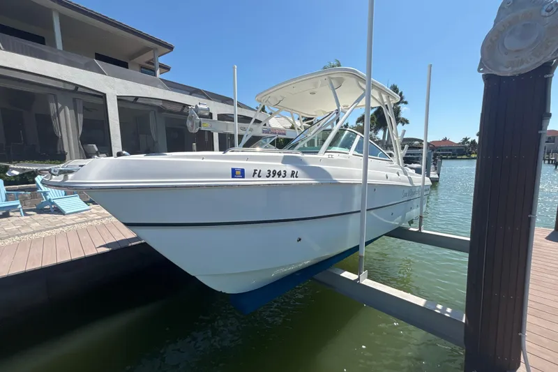 The Image of 2018 World Cat 230 SD boat docked at a marina, sunny day, waterfront view. - 1