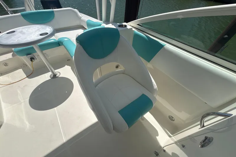 Slide: The Image of 2018 World Cat 230 SD boat interior with teal and white seating and table. - 11
