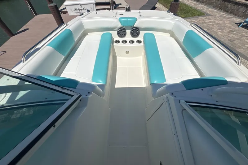Slide: The Image of 2018 World Cat 230 SD boat interior with teal and white seating, docked at marina. - 15