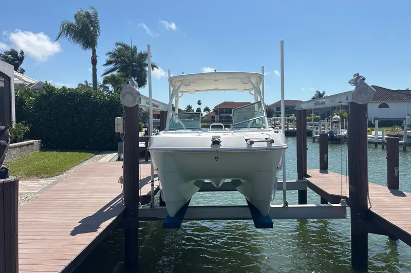 Slide: The Image of 2018 World Cat 230 SD boat docked on a lift in a sunny marina. - 20