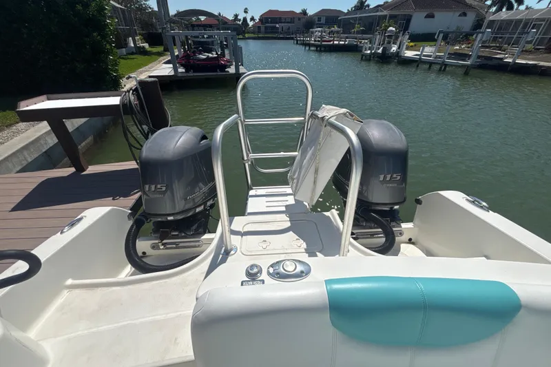 Slide: The Image of 2018 World Cat 230 SD boat with twin Yamaha 115 engines docked by waterfront homes. - 6