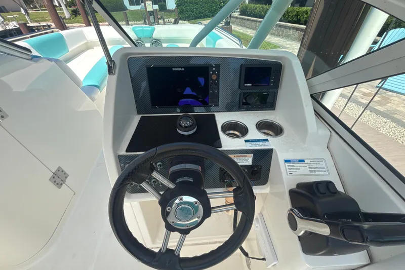 Slide: The Image of Cockpit of 2018 World Cat 230 SD boat with steering wheel and navigation controls. - 9