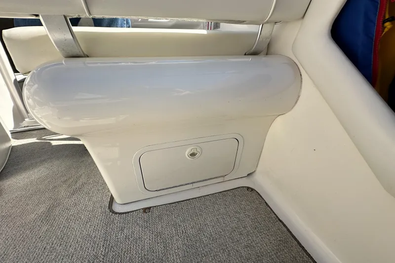 Slide: The Image of 1998 Sea Ray 215 Express Cruiser interior storage compartment with cushioned seating. - 13