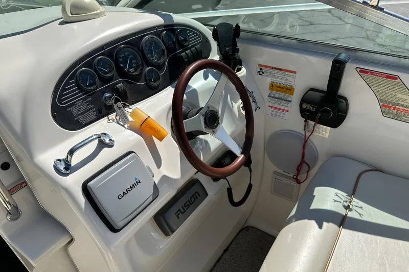 Slide: The Image of 1998 Sea Ray 215 Express Cruiser dashboard with Garmin navigation and wood steering wheel. - 18