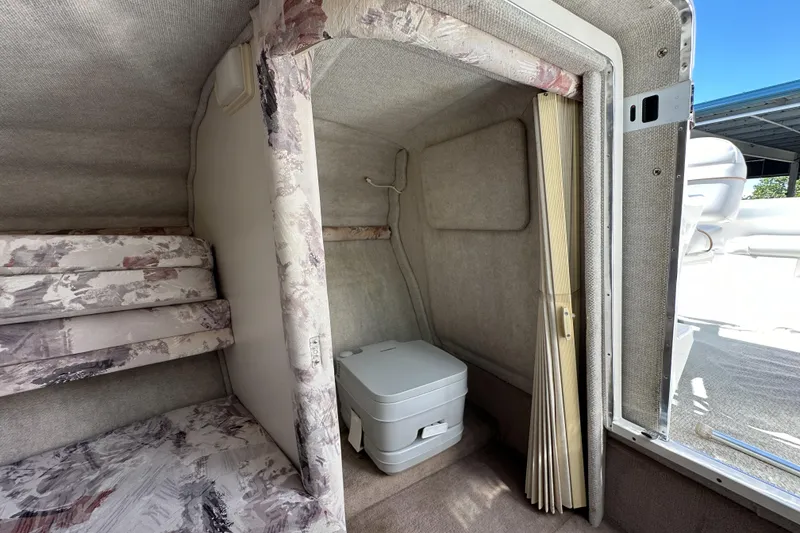 Slide: The Image of 1998 Sea Ray 215 Express Cruiser interior with compact toilet and patterned cushions. - 21