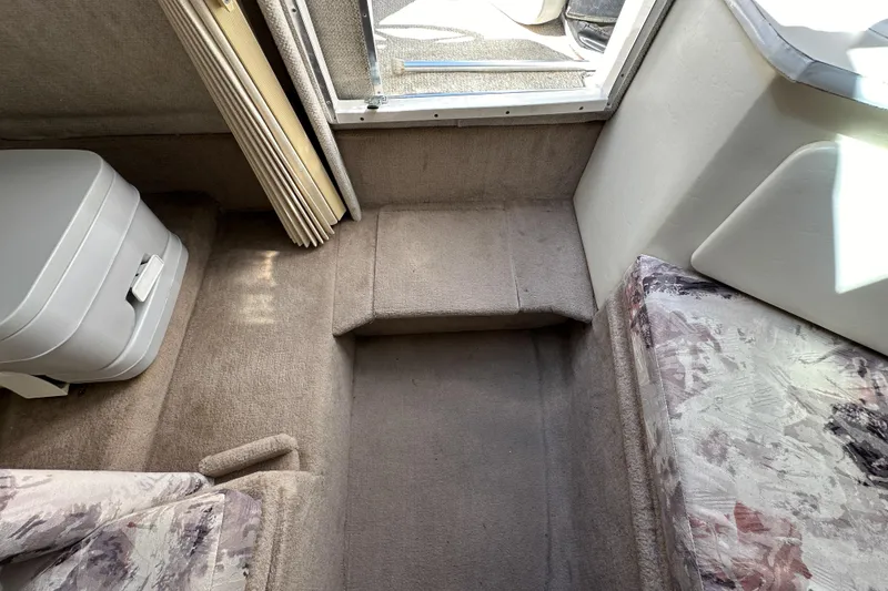Slide: The Image of Interior of 1998 Sea Ray 215 Express Cruiser with compact toilet and seating area. - 23