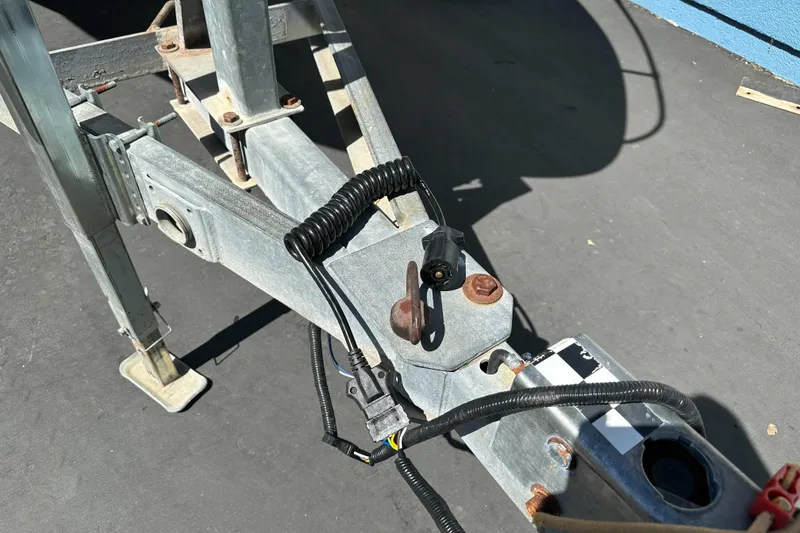 Slide: The Image of Trailer hitch and wiring for 1998 Sea Ray 215 Express Cruiser on pavement. - 8