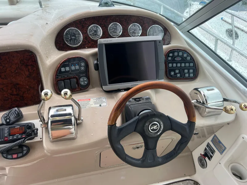Slide: The Image of Dashboard of a 2005 Sea Ray 340 Sundancer boat with steering wheel and controls. - 13