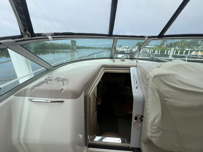 Slide: The Image of 2005 Sea Ray 340 Sundancer boat interior with covered seating and water view. - 17