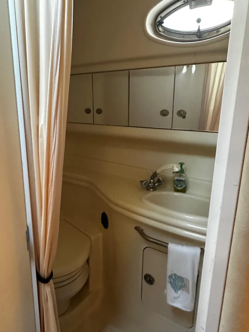 Slide: The Image of 2005 Sea Ray 340 Sundancer bathroom with sink, mirror, and porthole window. - 20